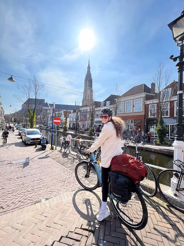 woman cycling through cobblestone streets of Delft