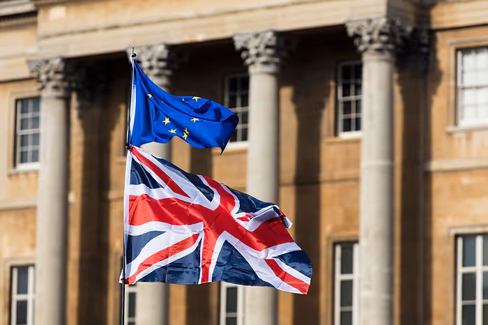european union and union jack flags in front of government building