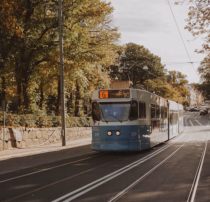 light blue tram going up road in Sweden