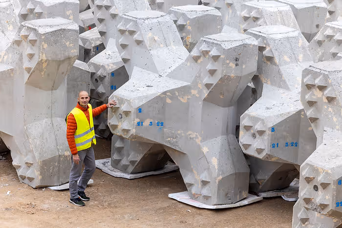 man standing next to concrete coral reef blocks