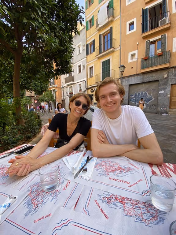 man and woman at restaurant table outdoors eating paella
