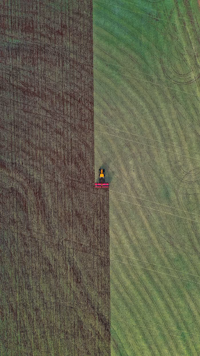 aerial shot of tractor harvesting crops
