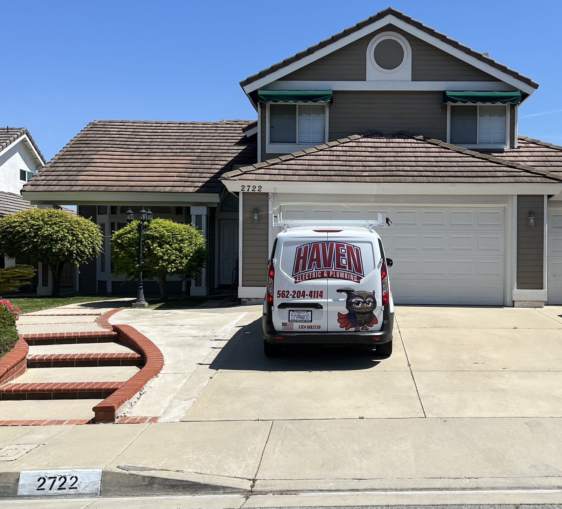 White service van with Haven Electric & Plumbing logo parked in the driveway of a suburban house numbered 2722.
