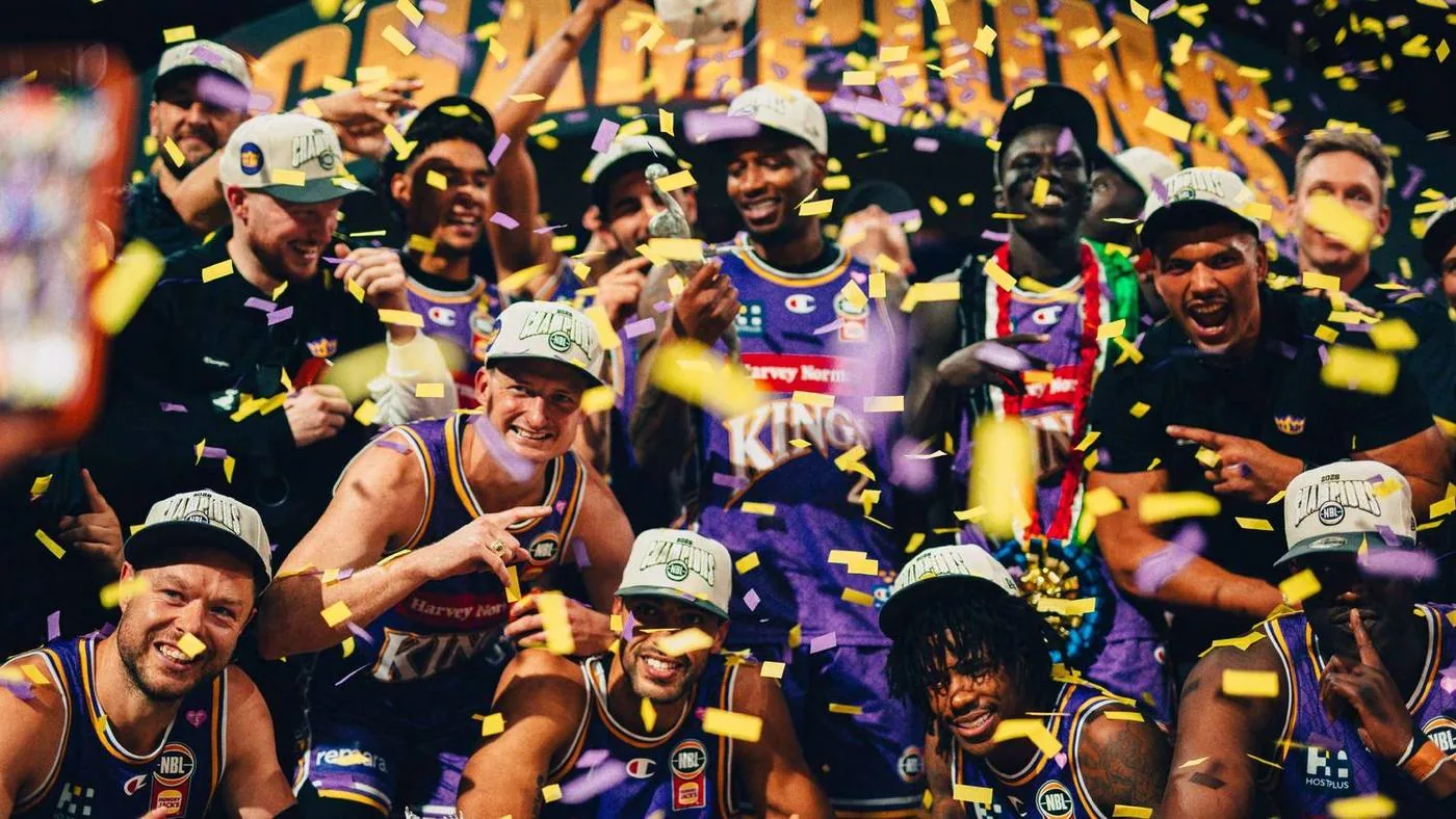 Sydney Kings players celebrate the Championship together under gold confetti