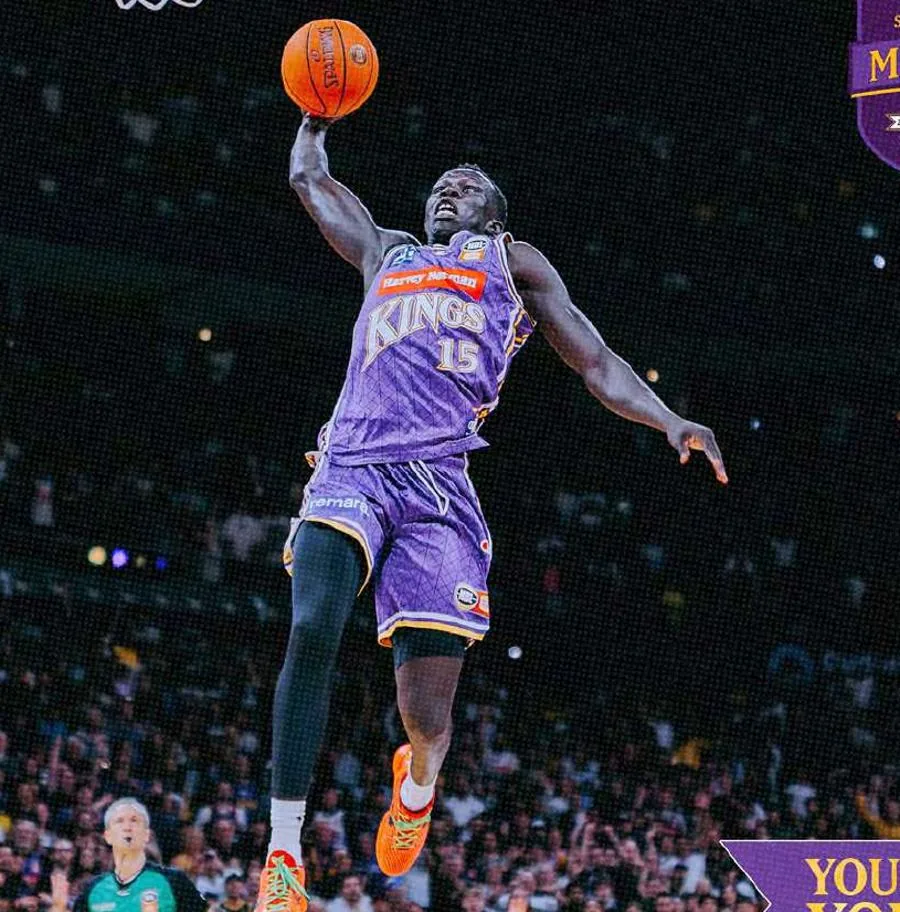 A Sydney Kings player celebrates on the rim in front of a packed Afterpay Arena