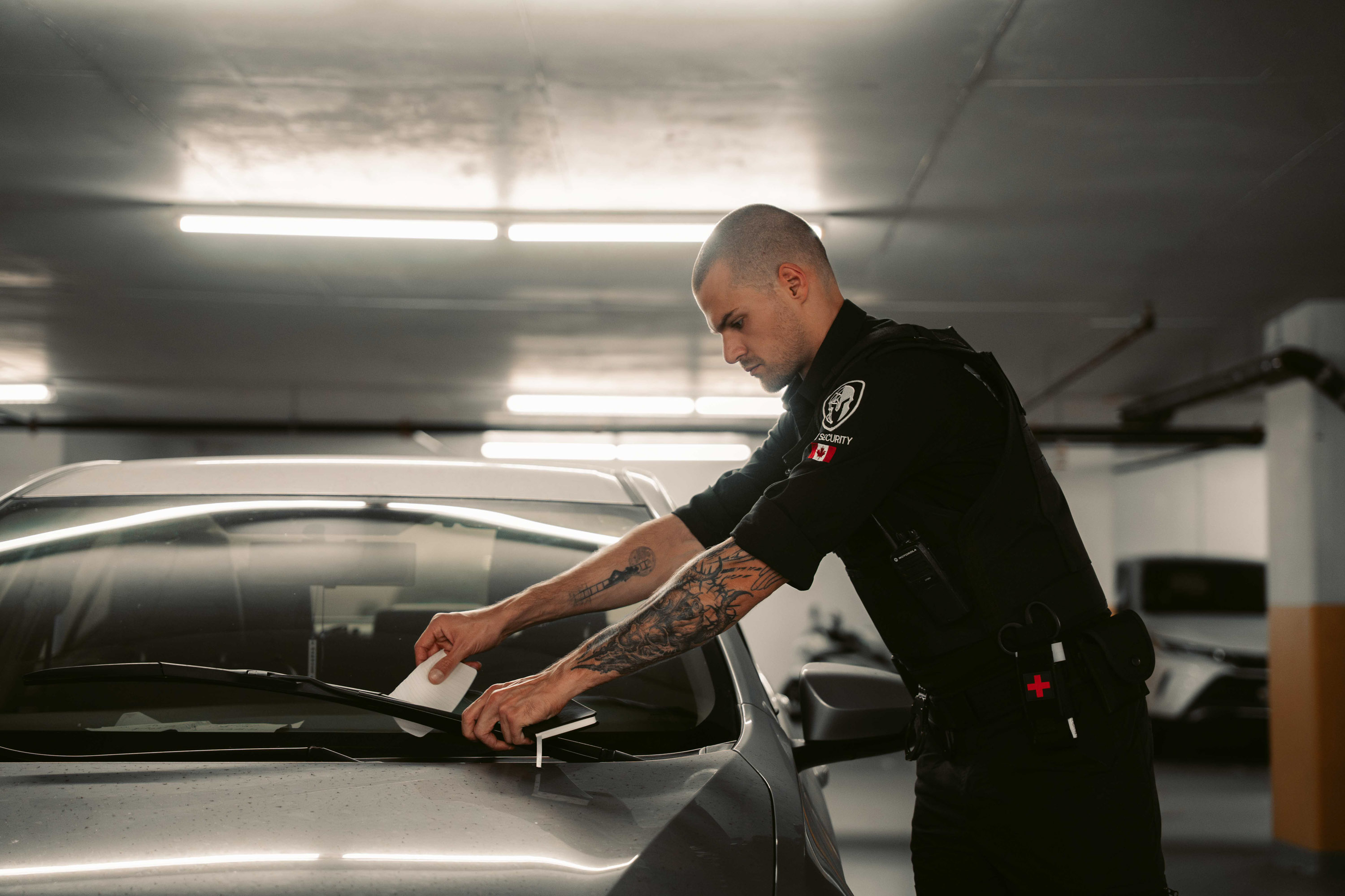 Grit Security officer documenting a vehicle during a parkade security patrol