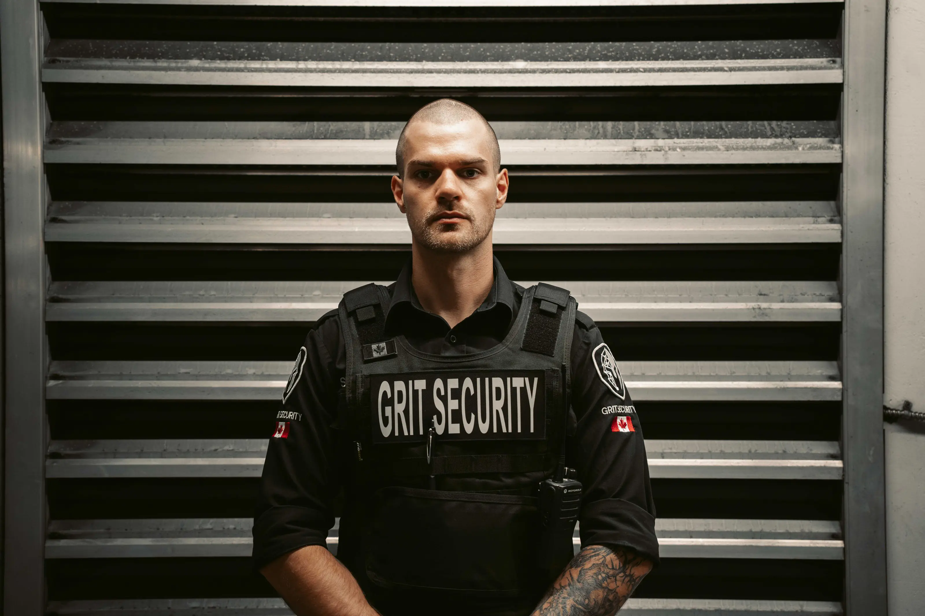 Uniformed Grit Security officer standing at a secured storefront.