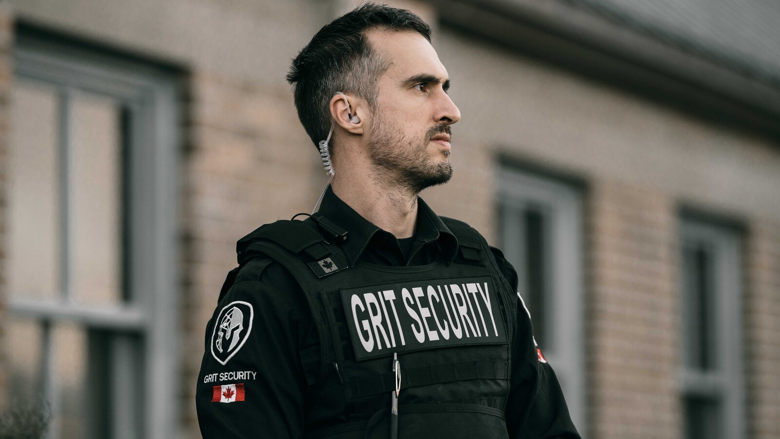 Uniformed Grit Security officer standing outside during a daytime security assignment.