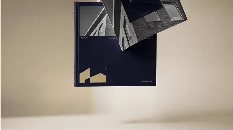 Two architectural magazines with navy blue covers and black-and-white building photos floating against a beige background.