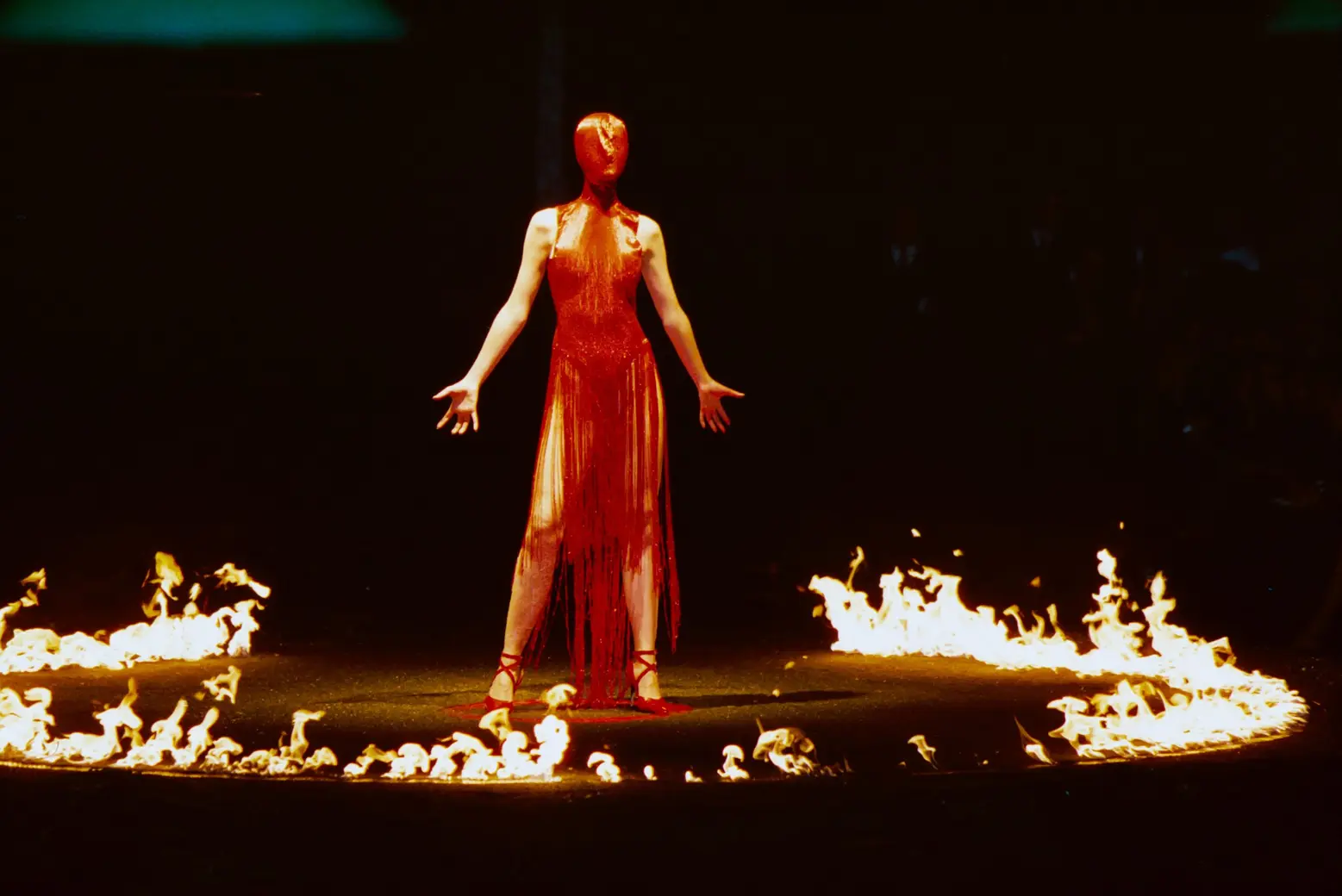 Erin O'Connor, in a red beaded dress and mask, stood in a circle of fire that was lignited around at the end of the show Erin O'Connor, in a red beaded dress and mask, stood in a circle of fire that was lignited around at the end of the show