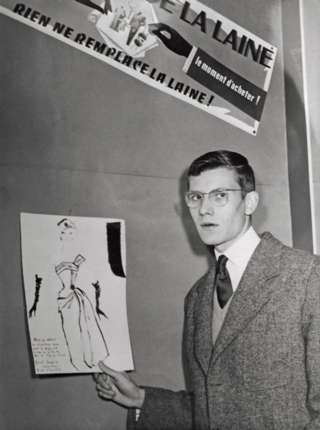 Yves Saint Laurent poses with a sketch of the design that won him third prize in the costume category at the Secrétariat international de la laine competition, Paris, 1953 Yves Saint Laurent poses with a sketch of the design that earned him third place in the costume category at the Secrétariat International de la Laine competition in Paris, 1953