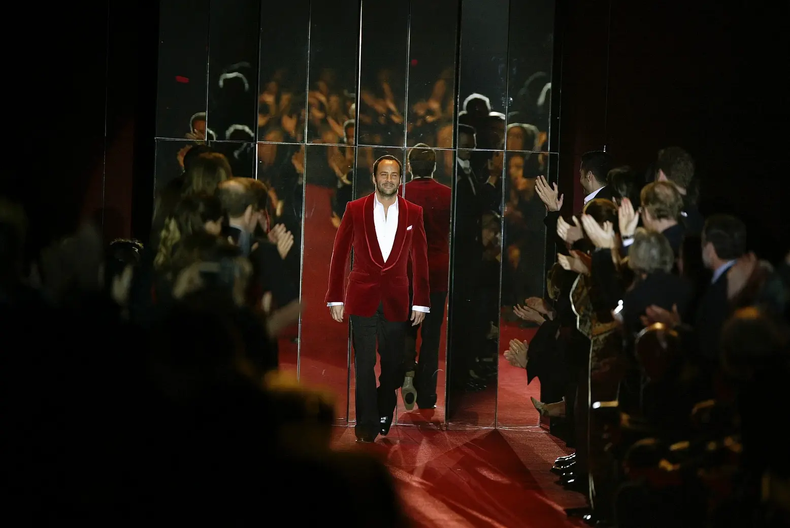This captures Tom Ford taking his final bow at the conclusion of the Yves Saint Laurent Fall 2004 collection presentation
