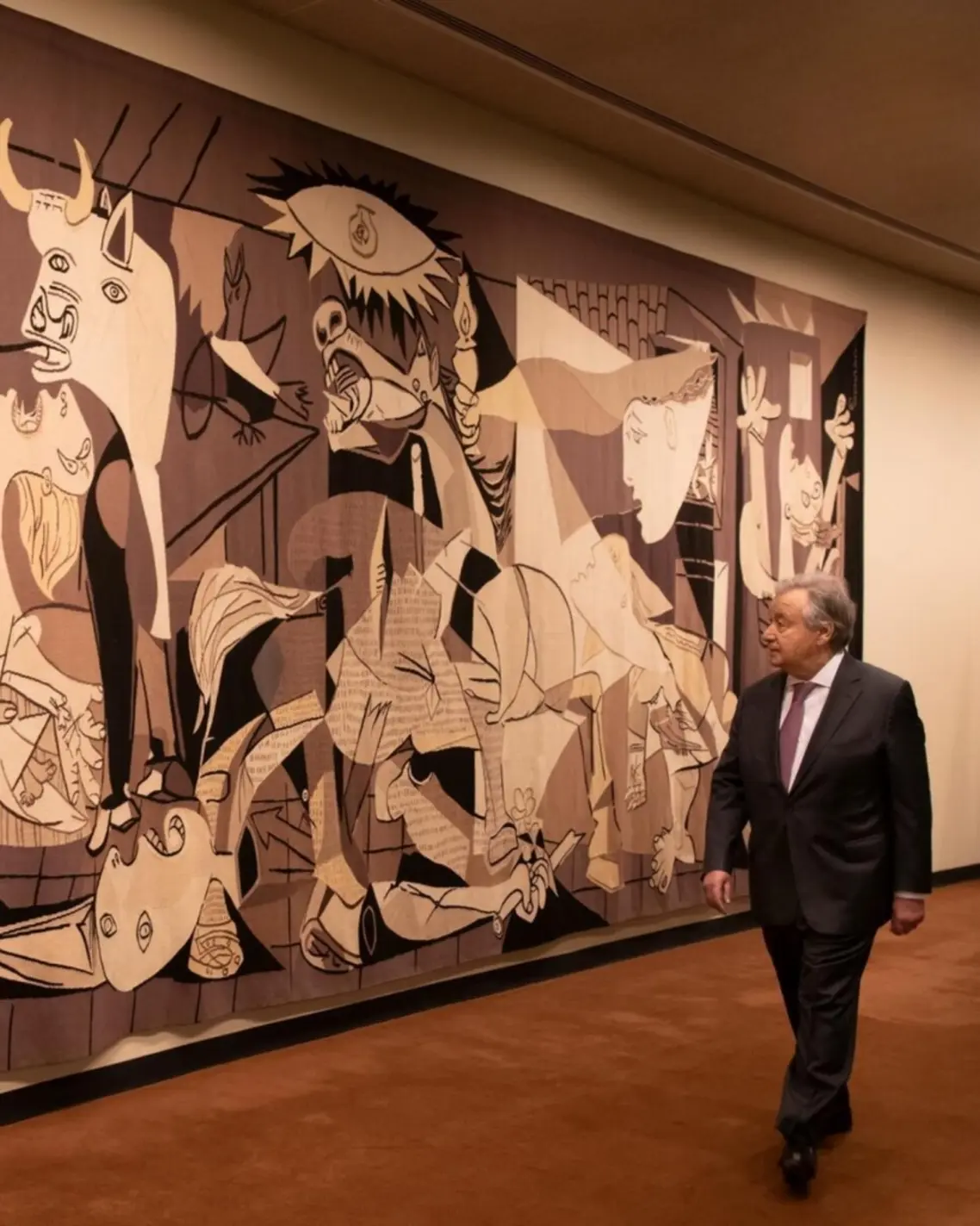 Secretary-General António Guterres passes by the Guernica tapestry outside the United Nations Security Council Chamber Oscar Niemeyer