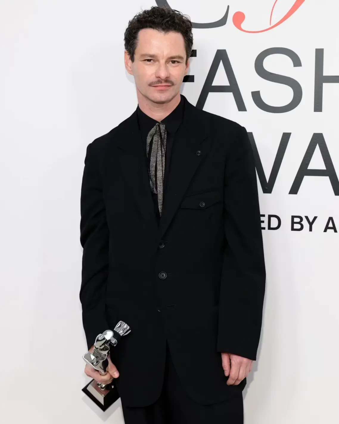 Henry Zankov with his CFDA Award in 2024 Henry Zankov