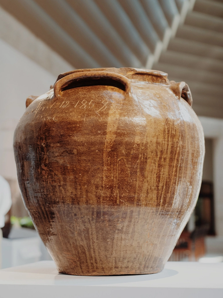 This monumental 25-gallon, four-handled alkaline-glazed stoneware "poem jar", made by the renowned 19th-century enslaved African American potter David Drake, achieved a historic milestone when it sold at a Crocker Farm auction for $1,560,000, breaking the world auction record for American pottery ceramic