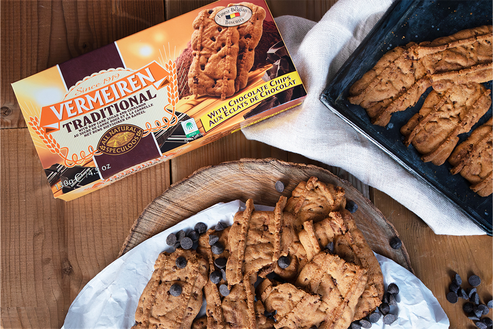 Vermeiren Speculoos met chocoladestukjes op een ronde houten plank, met chocoladedruppels erop