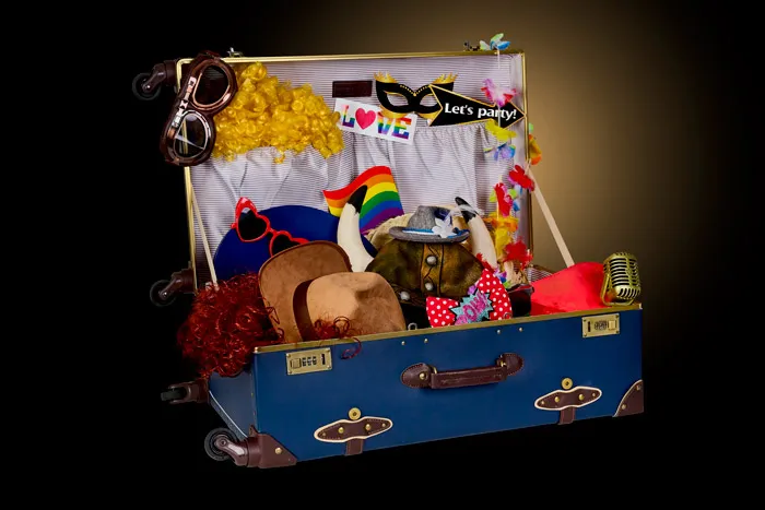 Innenraum mit Holzparkettboden, Fotostudioausrüstung und festlicher goldener Glitzer-Hintergrund mit weißen Luftballons.
