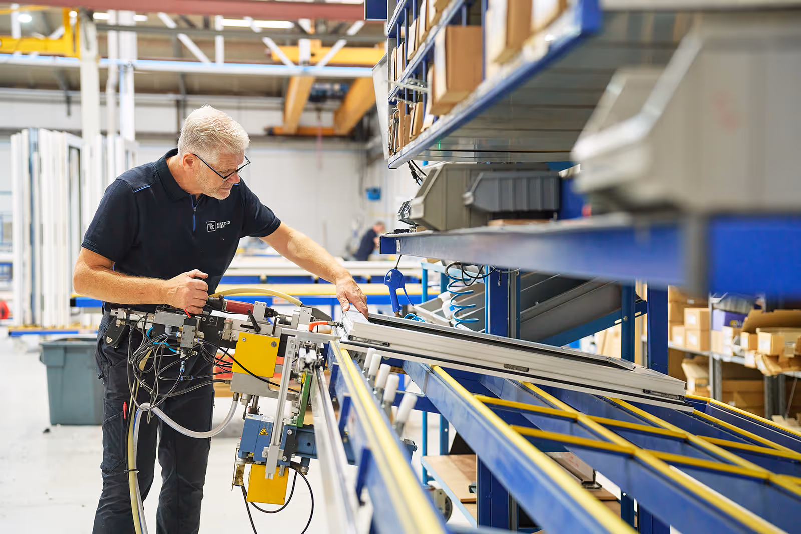 Man die een kunststof raamprofiel inspecteert en bewerkt in een productieomgeving.