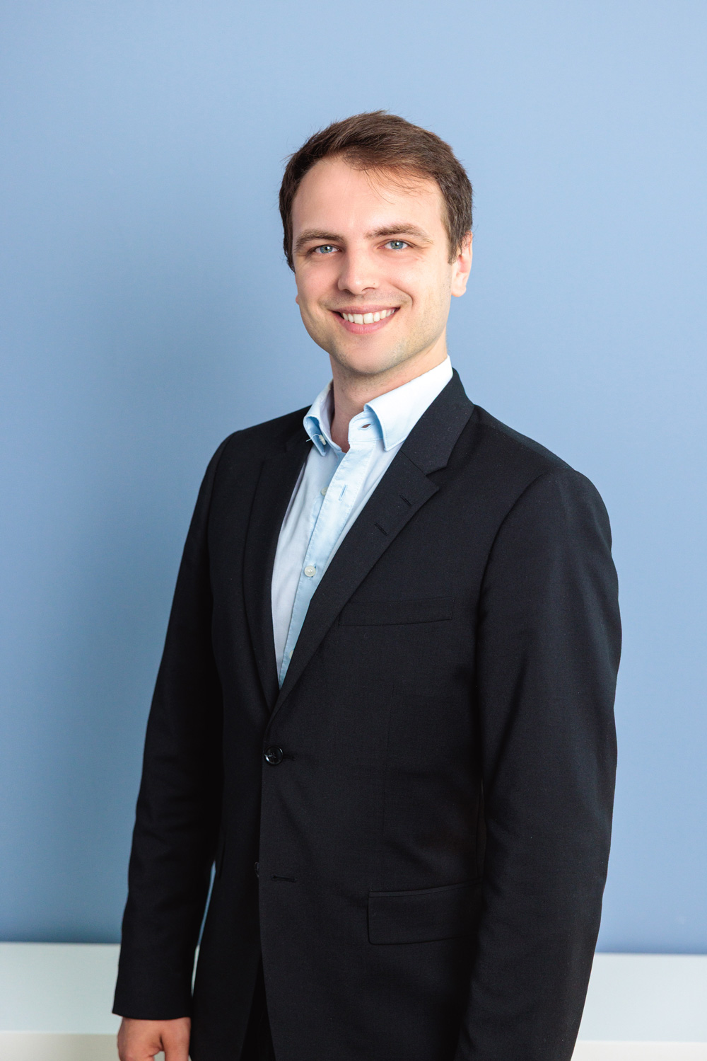 Mann in Business-Kleidung vor neutralem Hintergrund