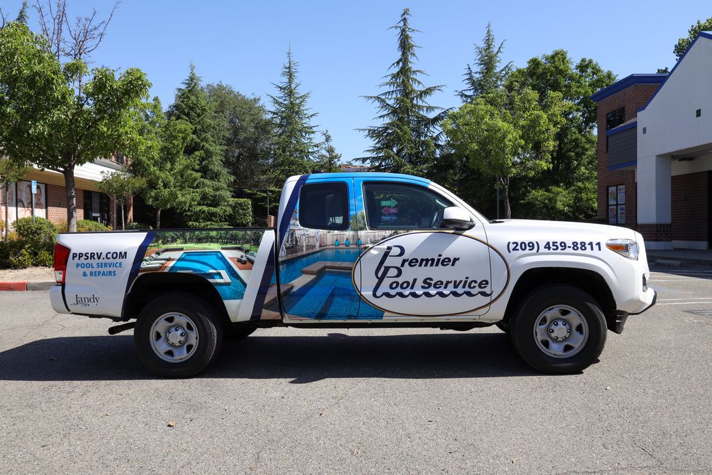 White pickup truck with Premier Pool Service branding, pool images on the side, and contact number 209-459-8811.