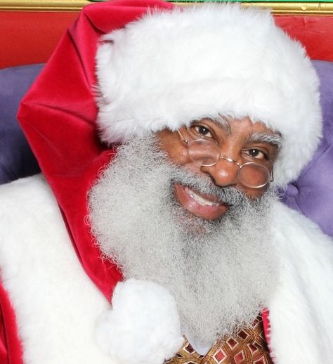 Portrait of Santa Claus wearing glasses and a red hat with white fur trim.
