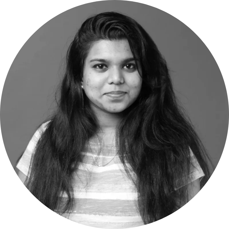 Black and white portrait of a woman with long hair wearing a striped shirt, smiling slightly against a plain background.