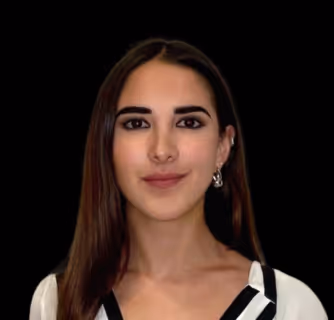 Portrait of a woman with long dark hair, wearing a white top with black straps and a dangling earring, against a black background.