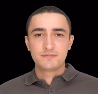 Woman standing on sidewalk wearing a dark blue denim dress with front buttons and black ankle boots.