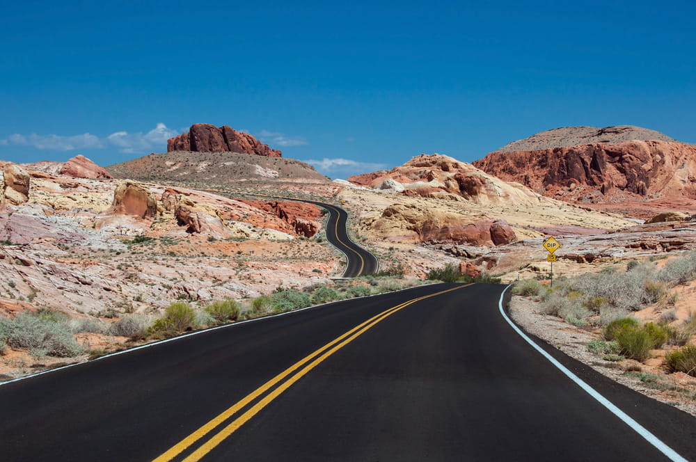 Open desert highway winding through red rock formations in Nevada—symbolizing the journey and security provided by Nevada contractor license bonds.