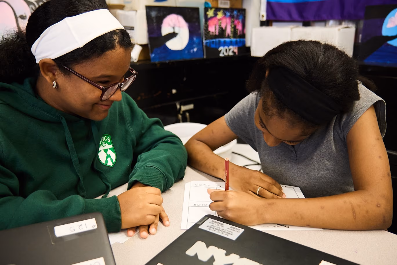 Two students collaborating on a worksheet in an art classroom
