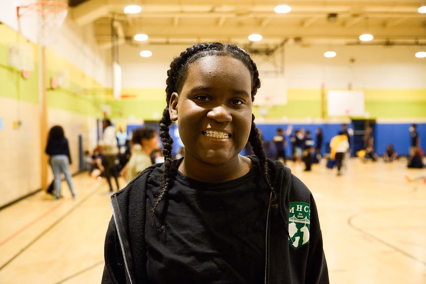 Student smiling in school gymnasium during an activity event