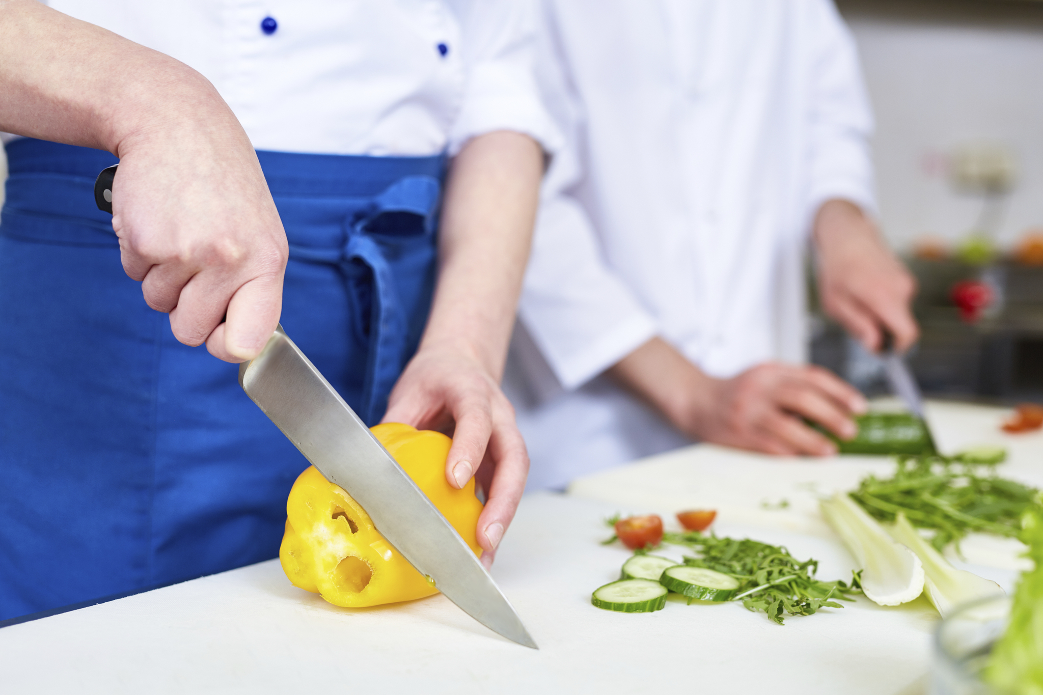 a cook slicing a pepper