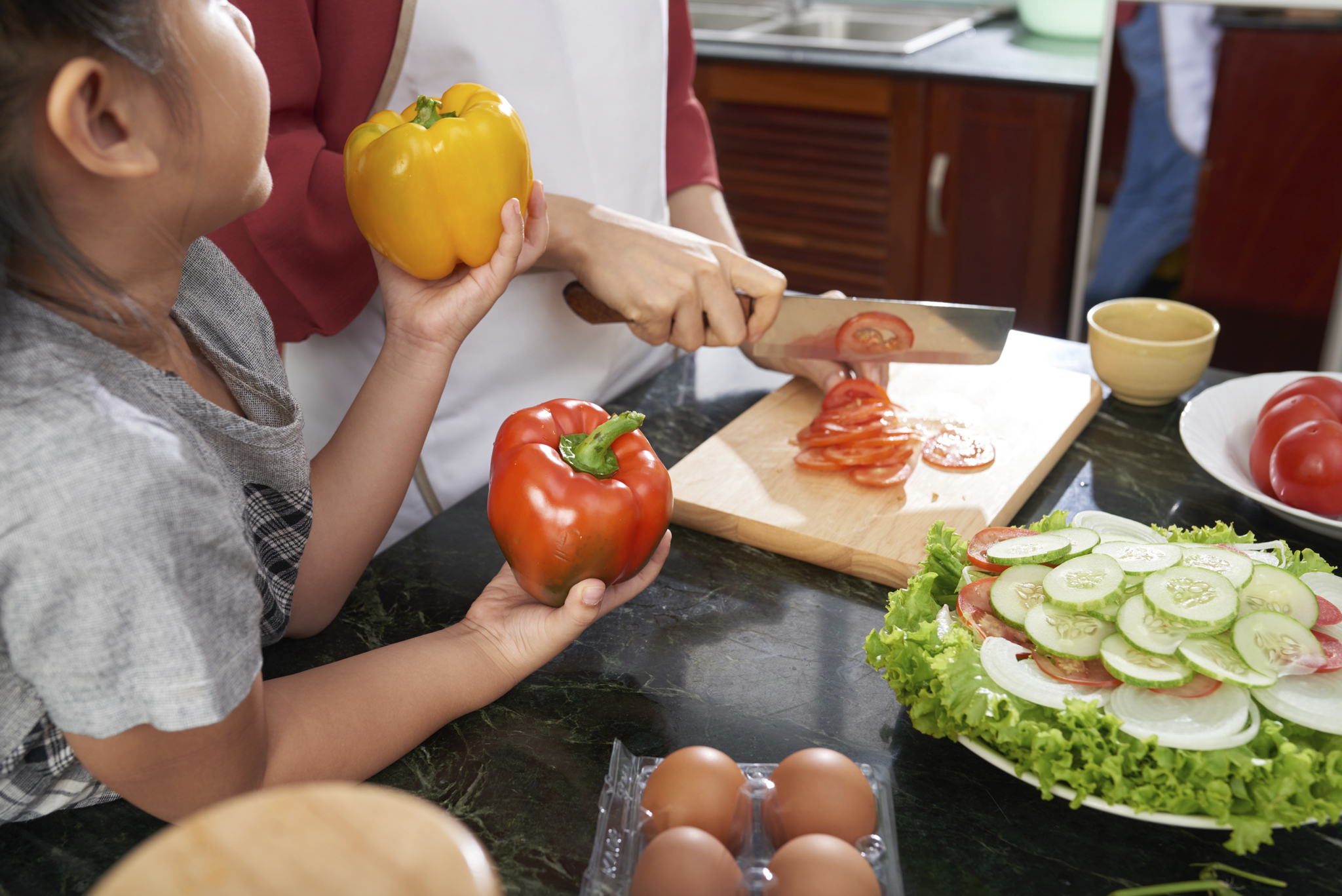 a child helping her mother in the kitchen
