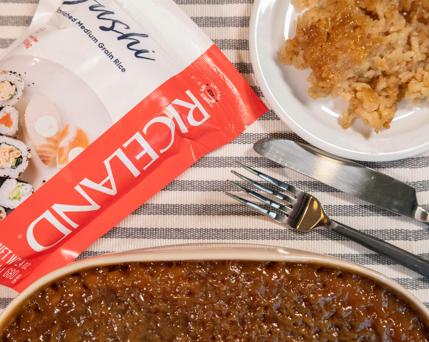 Photo of table spread with Biko in casserole dish, plated Biko and silverware.