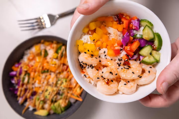 A bowl of food with a fork and a bowl of riceAI-generated content may be incorrect.