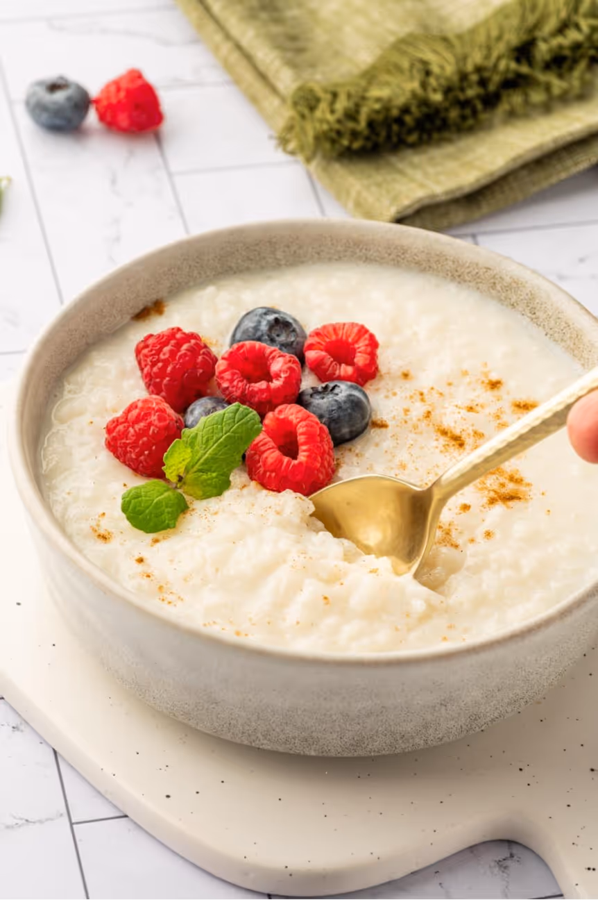 A bowl of oatmeal with berries and a spoonAI-generated content may be incorrect.