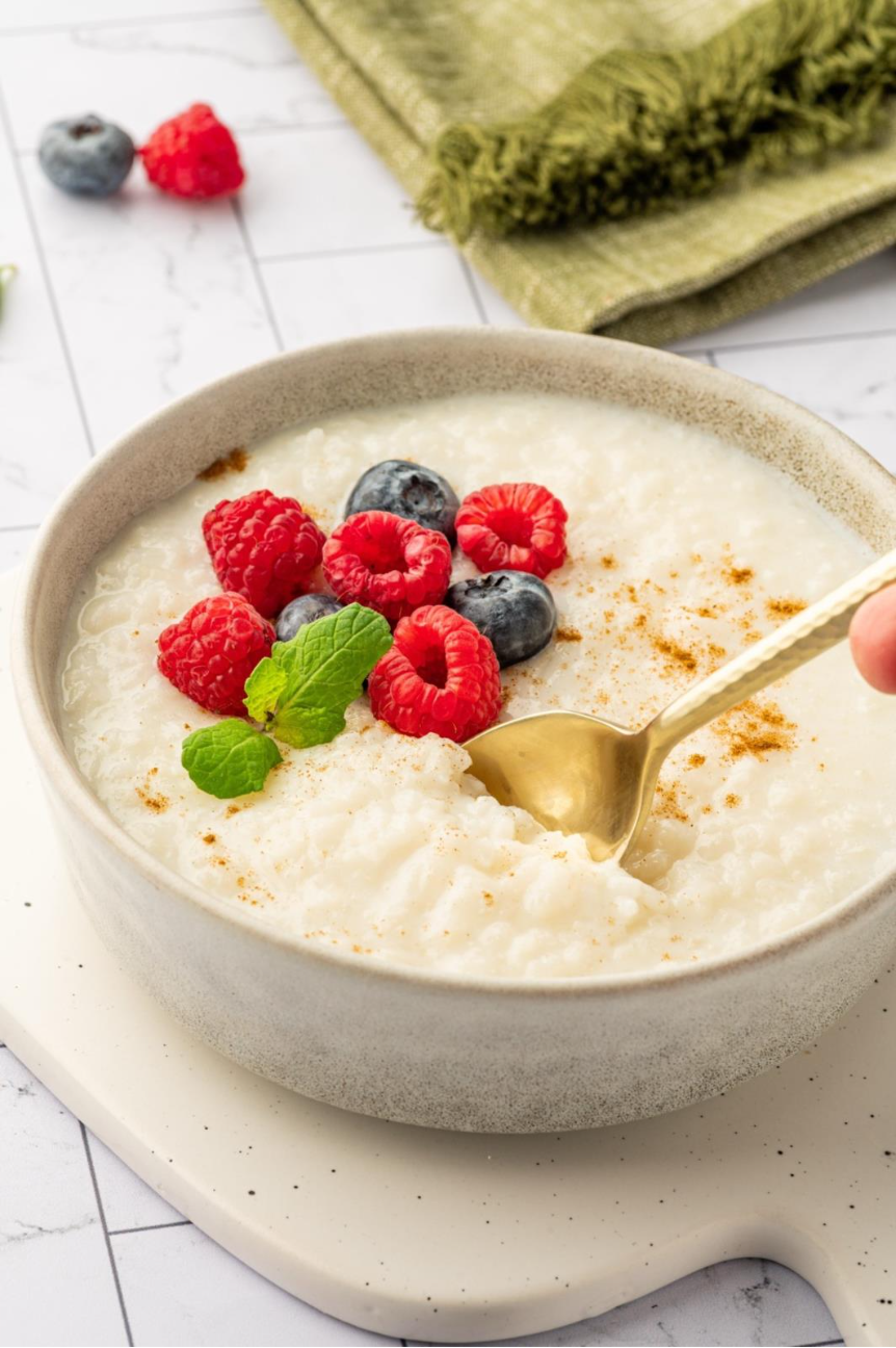 A bowl of oatmeal with berries and a spoonAI-generated content may be incorrect.