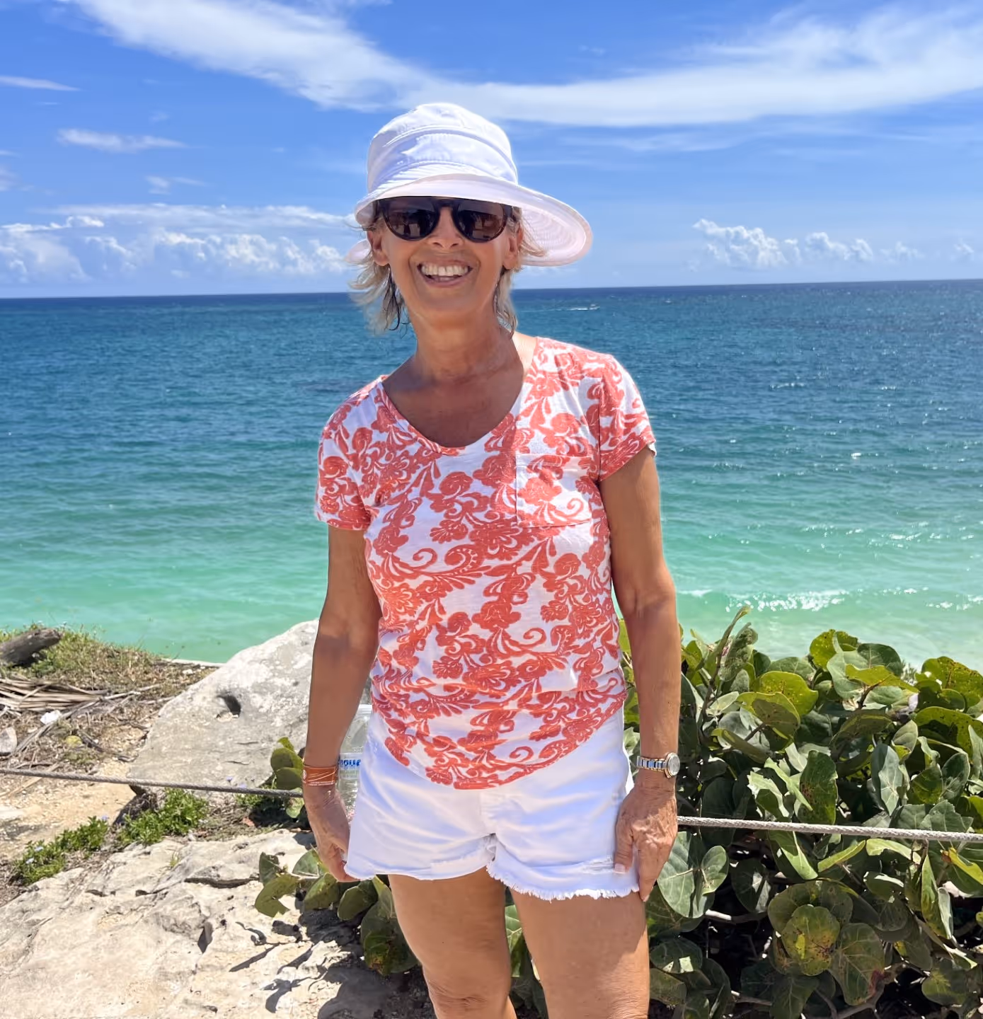 Ellen with a blue ocean and beach behind her