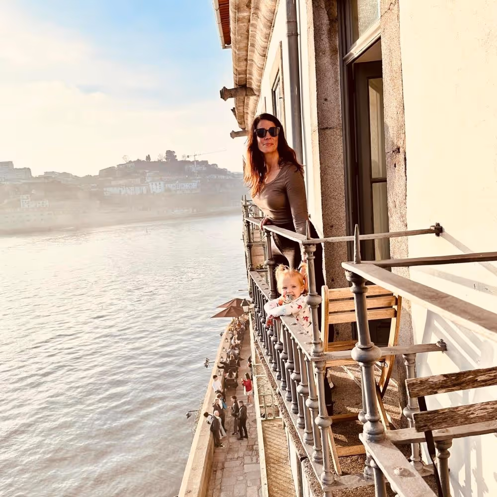 Nicole standing with daughter on a balcony