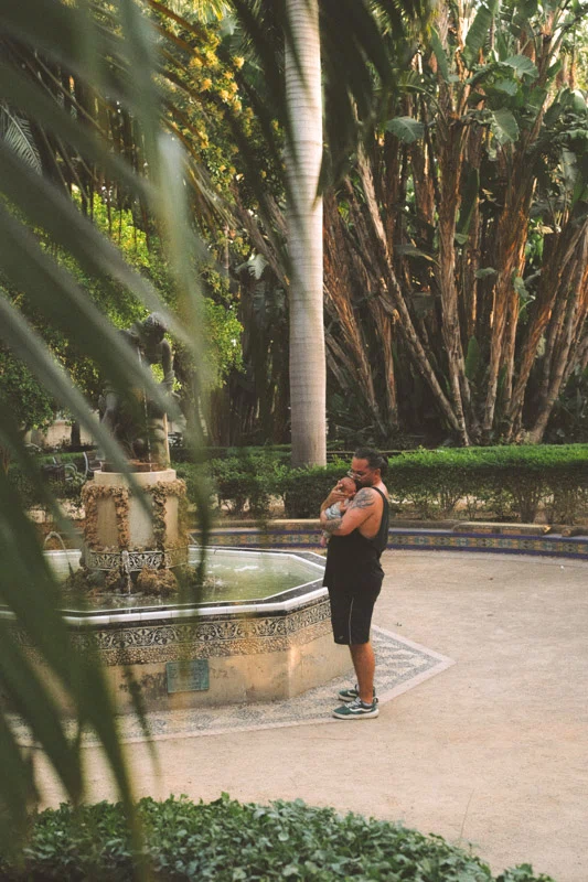 A dad holding his newborn daughter in a park in Malaga center 