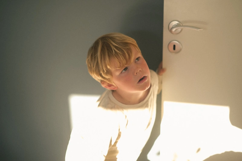 Sun reflection hitting a boy indoor