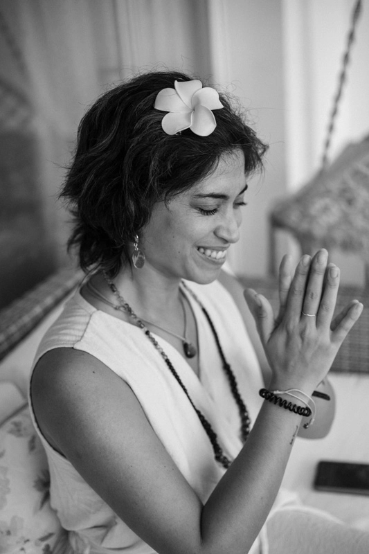 A black and white photo of a women holding her hand in prayer of gratitude