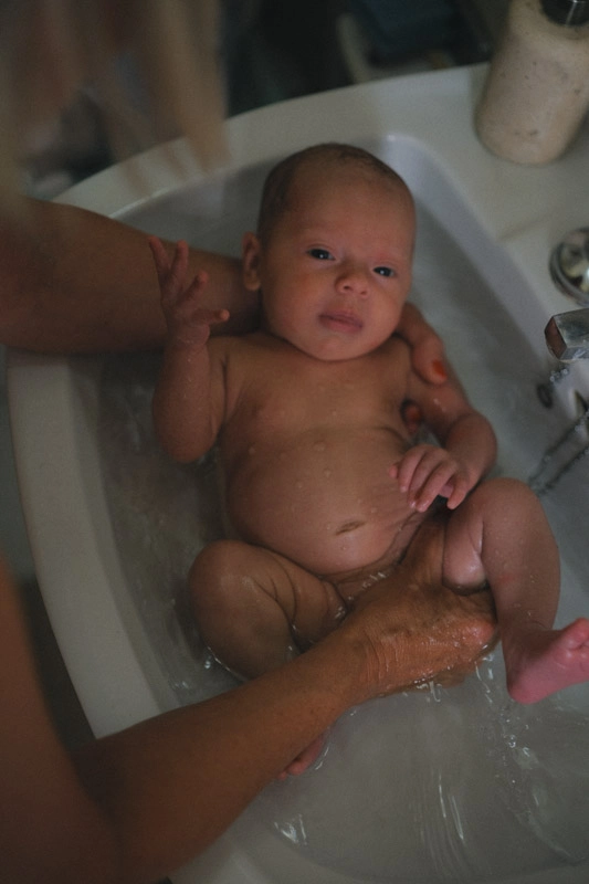 A mother bathing her newborn baby 