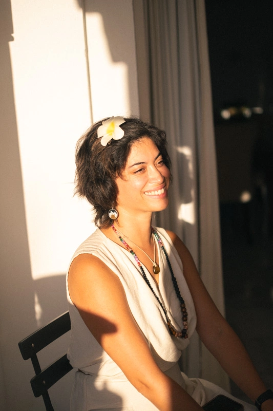 The sun shines on women in a white dress smiling