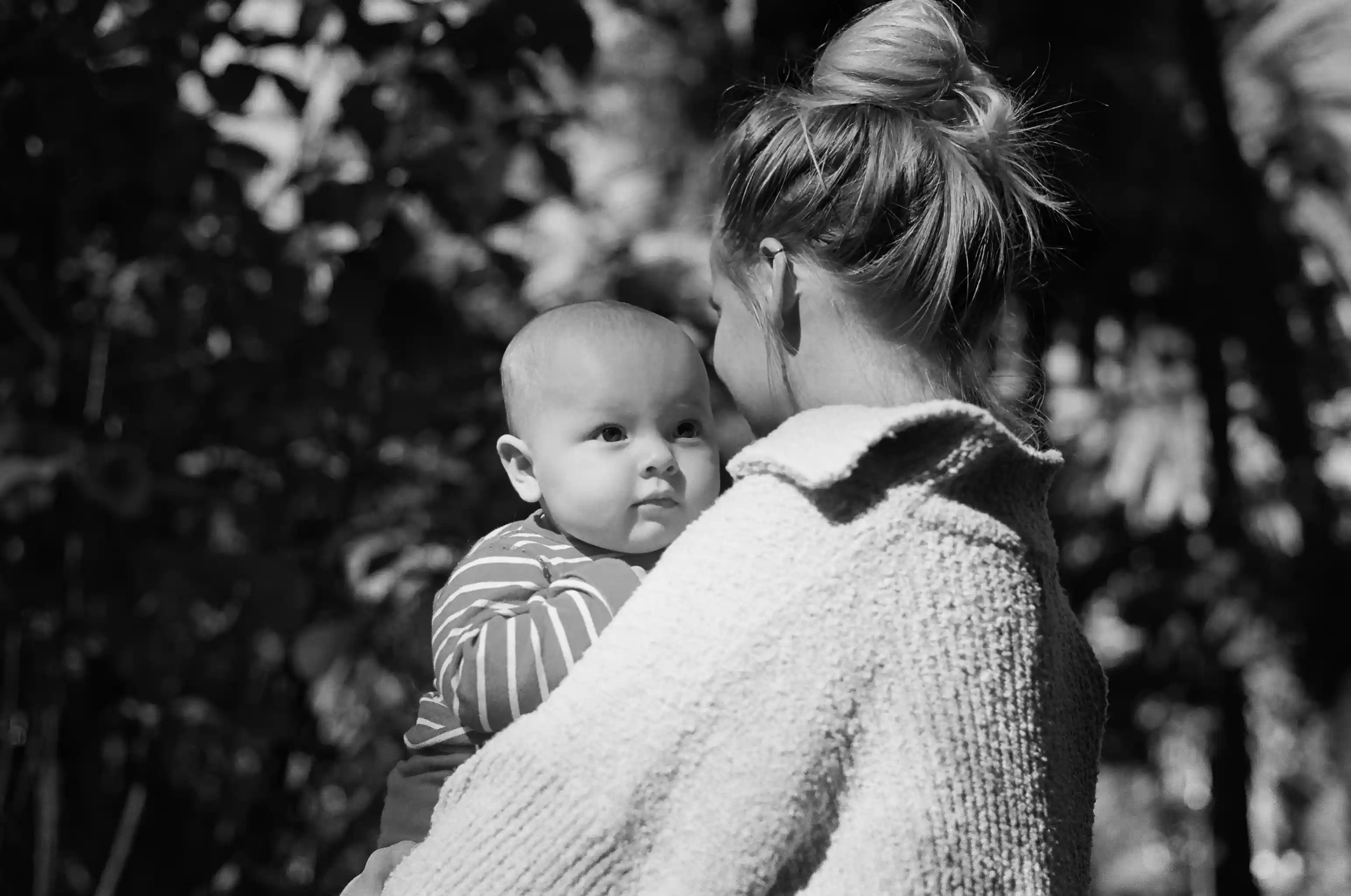 A mom holding here baby in a park in Malaga