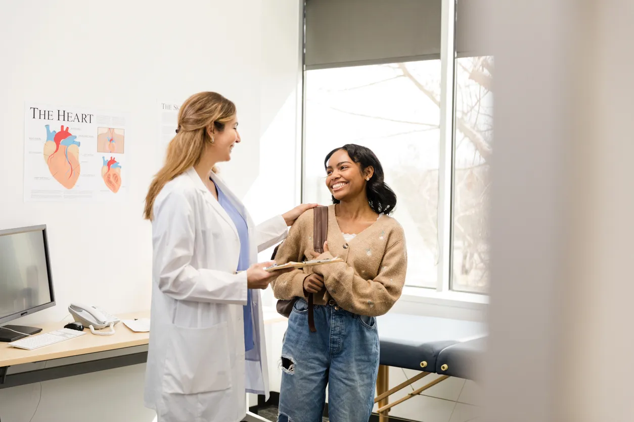 Doctor in a white coat talking with a young woman patient in a medical office