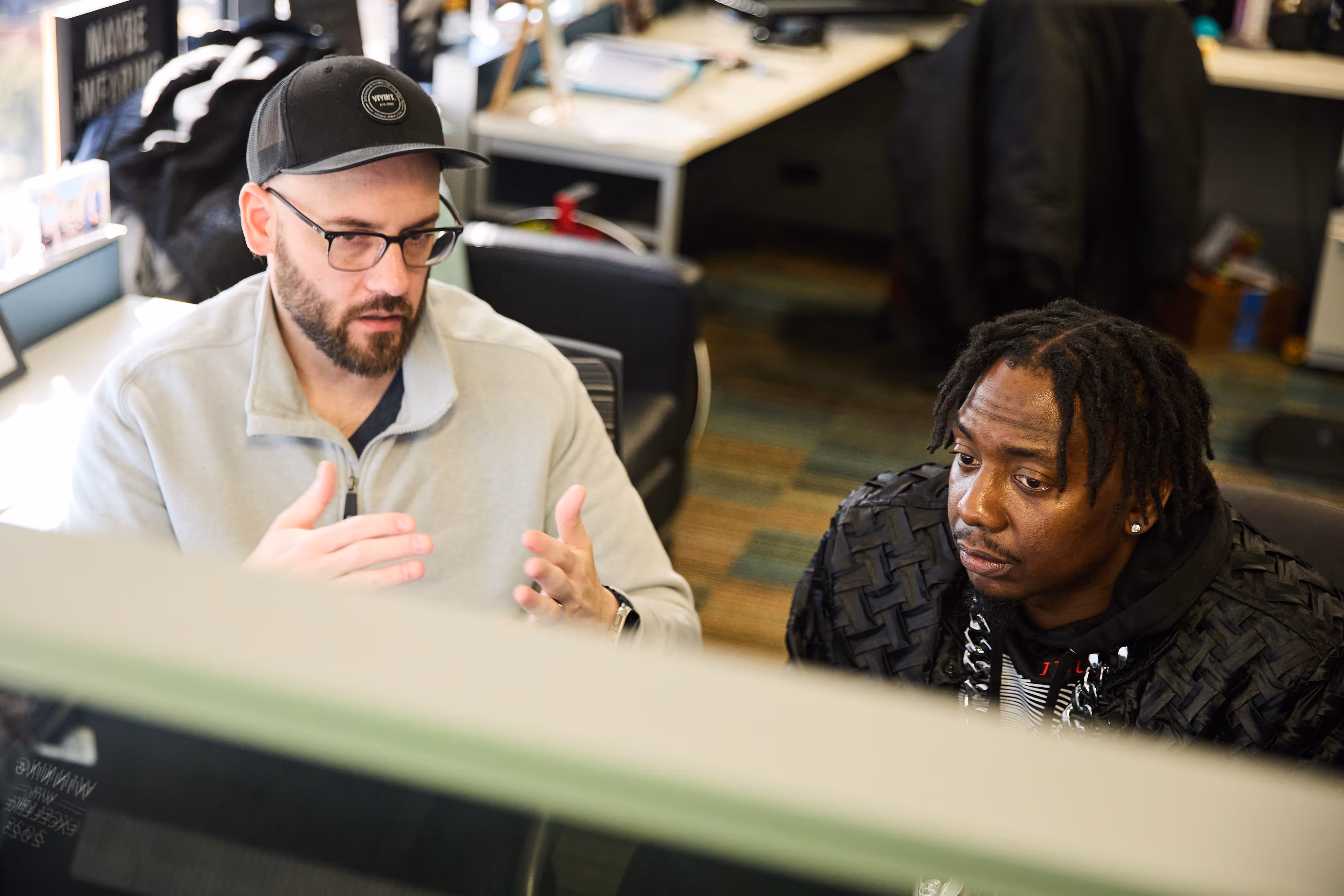 Jason Tranowicz sitting at a computer teaching someone who is in MC Academy.
