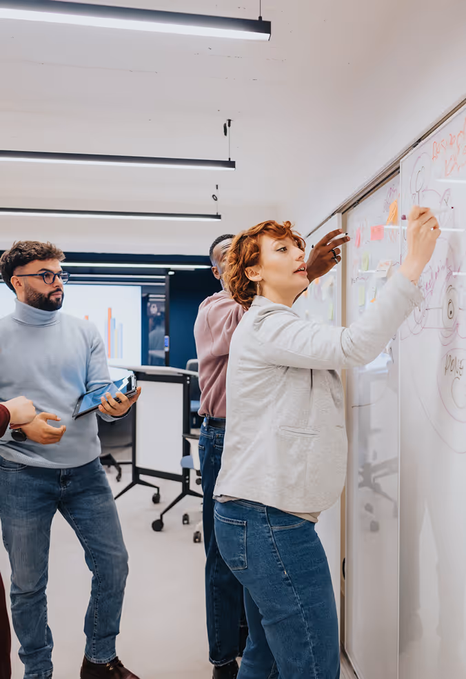 Group of people writing on a whiteboard.