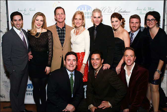A group of the Broadway Dreams leadership team standing on a red carpet in front of the event's branded backdrop.
