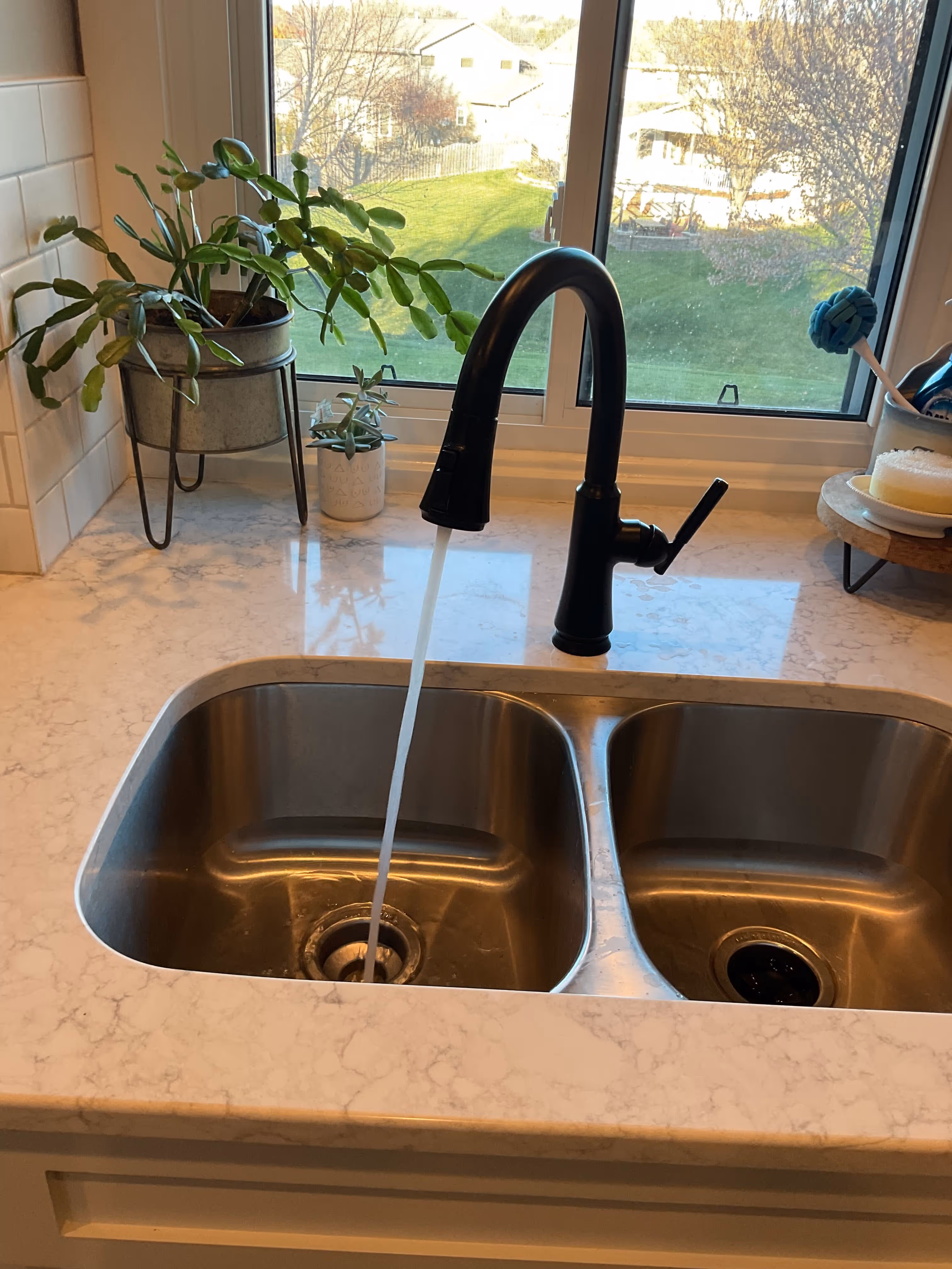 Technician installing a customer-supplied faucet in an Omaha kitchen